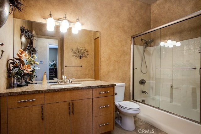 full bathroom featuring toilet, vanity, shower / bath combination with glass door, and tile patterned flooring