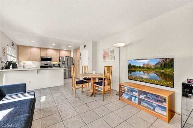 dining space featuring sink and light tile patterned floors