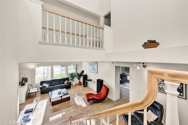 living room featuring wood-type flooring and a towering ceiling