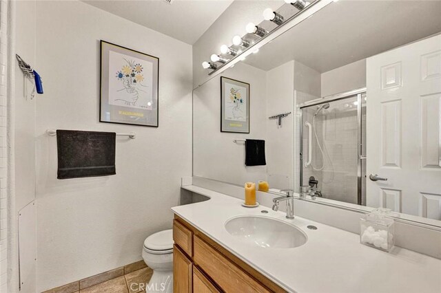 bathroom with tile patterned flooring, vanity, an enclosed shower, and toilet