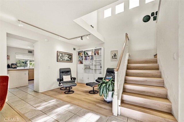 stairs with hardwood / wood-style floors and track lighting