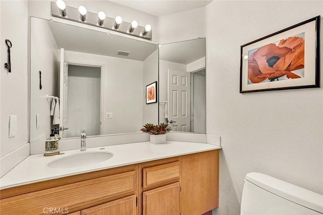 bathroom featuring vanity and toilet