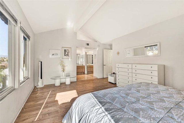 bedroom featuring hardwood / wood-style flooring, ensuite bathroom, and vaulted ceiling with beams