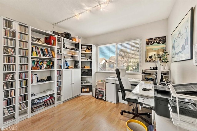 office space with rail lighting and light wood-type flooring