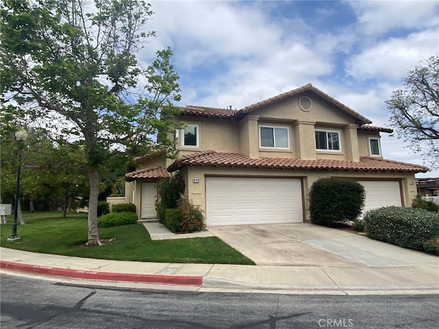 mediterranean / spanish home with a garage and a front yard