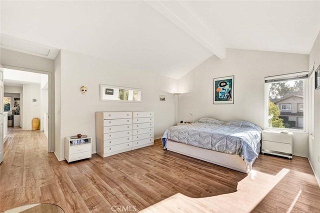 bedroom featuring lofted ceiling with beams, multiple windows, and light hardwood / wood-style flooring