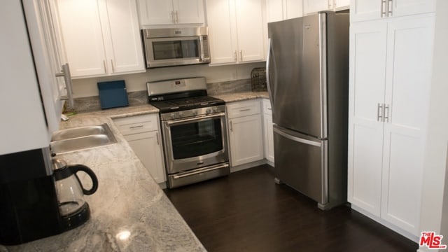 kitchen featuring white cabinetry, light stone counters, and stainless steel appliances