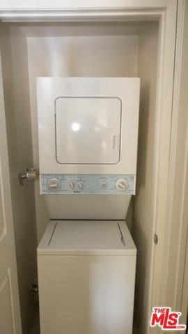 clothes washing area with stacked washer and dryer