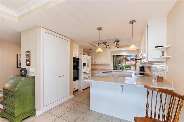 kitchen featuring white cabinetry, black appliances, a raised ceiling, decorative light fixtures, and kitchen peninsula