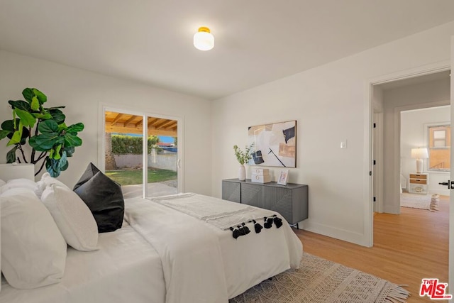 bedroom featuring hardwood / wood-style flooring and access to outside