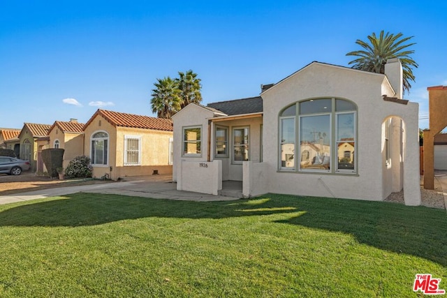 mediterranean / spanish home with a front lawn