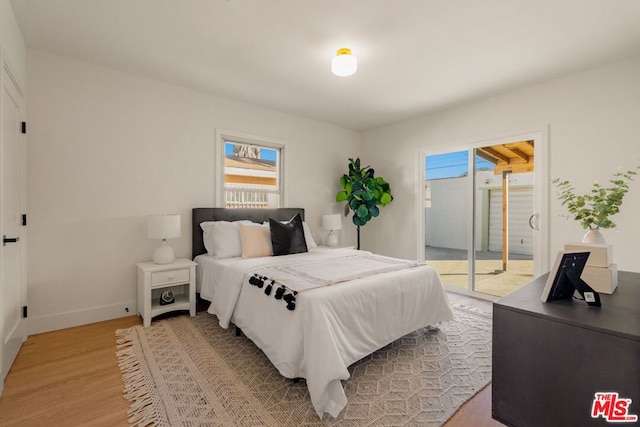 bedroom featuring access to exterior and light hardwood / wood-style floors