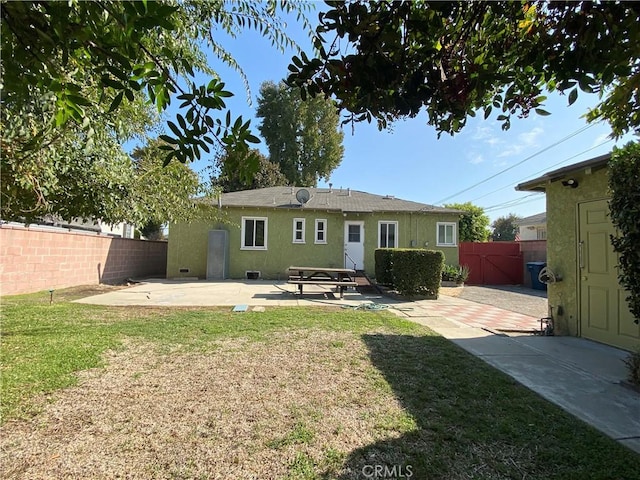 rear view of property with a patio area and a lawn