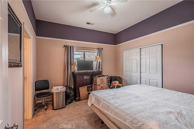 carpeted bedroom with ceiling fan and a closet