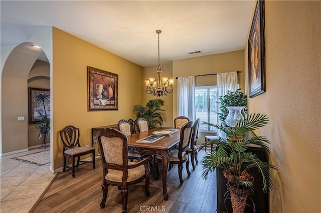 dining space with a chandelier and light wood-type flooring