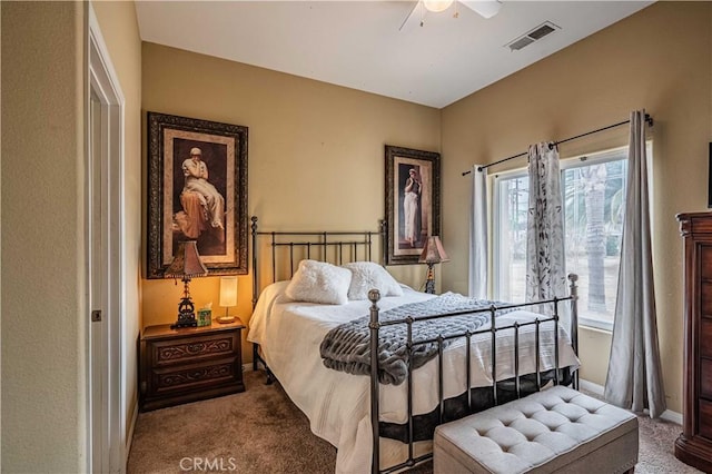 carpeted bedroom featuring multiple windows and ceiling fan