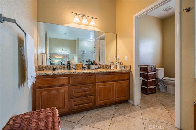 bathroom with tile patterned flooring, vanity, a shower with door, and toilet