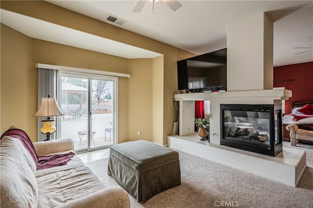 living room with carpet, ceiling fan, and a multi sided fireplace