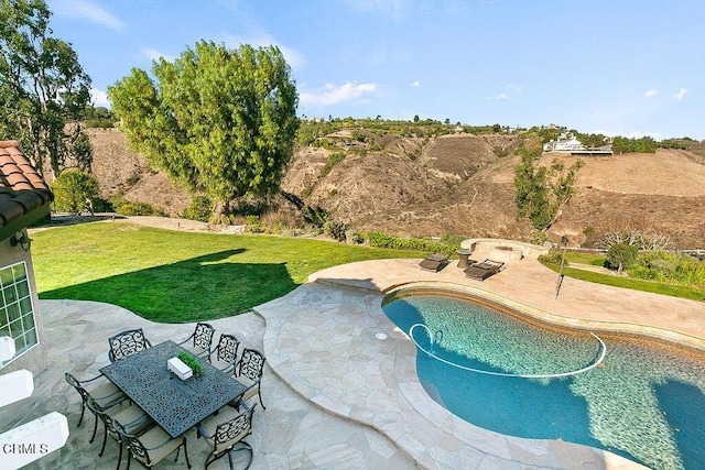 view of pool featuring a lawn and a patio