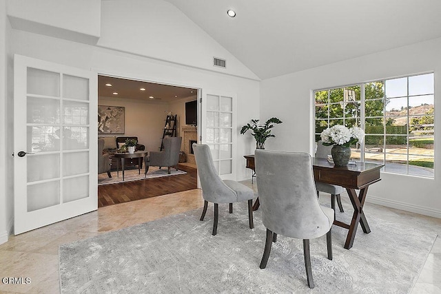 dining area featuring light tile patterned floors, high vaulted ceiling, and french doors