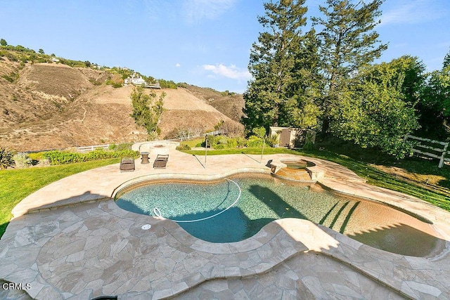 view of swimming pool featuring a mountain view, a patio, and an in ground hot tub