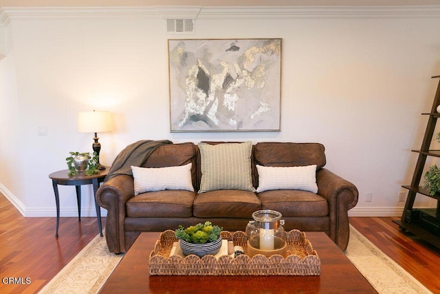 living room featuring wood-type flooring and ornamental molding