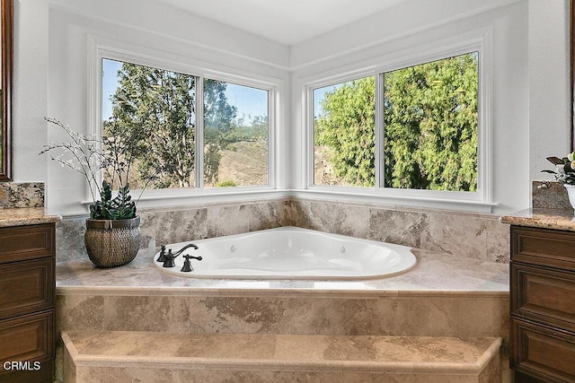 bathroom with vanity and tiled bath