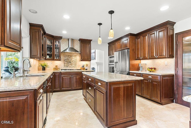 kitchen featuring tasteful backsplash, stainless steel appliances, a center island, and wall chimney range hood