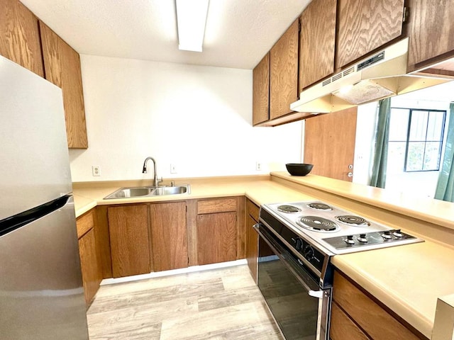 kitchen with sink, light hardwood / wood-style flooring, stainless steel refrigerator, electric range, and kitchen peninsula