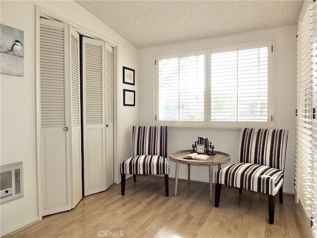 sitting room with light hardwood / wood-style flooring and a textured ceiling