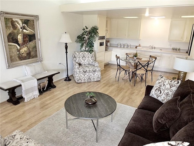 living room with sink and light hardwood / wood-style flooring