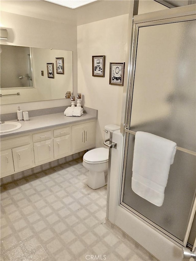 bathroom with walk in shower, vanity, and toilet