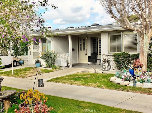 bungalow-style house featuring ac unit and a front yard