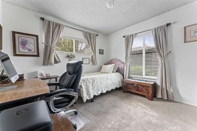 bedroom featuring a textured ceiling, multiple windows, and carpet flooring