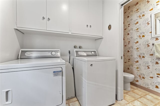 clothes washing area featuring wallpapered walls, baseboards, cabinet space, and independent washer and dryer