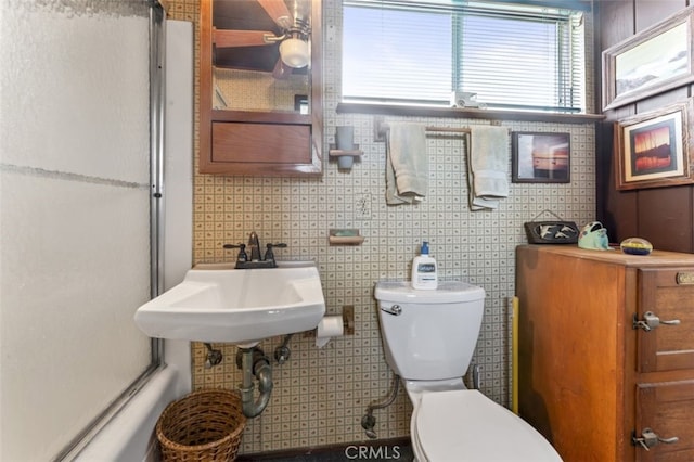 full bathroom featuring a sink, toilet, and an enclosed shower