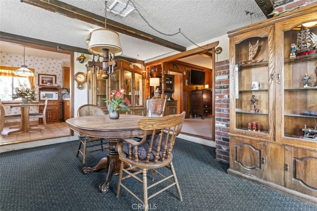 dining space with visible vents, dark colored carpet, a textured ceiling, and beamed ceiling