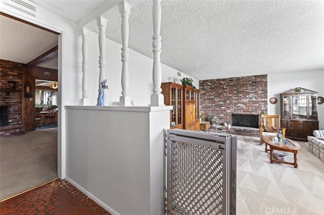 living room featuring a brick fireplace, a textured ceiling, visible vents, and carpet flooring