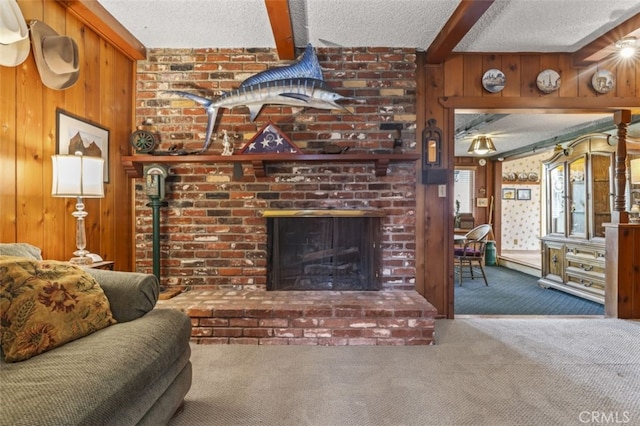 living room featuring a textured ceiling, a fireplace, carpet flooring, and beamed ceiling