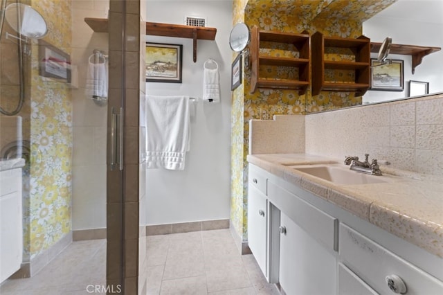 full bathroom with visible vents, backsplash, vanity, tile patterned flooring, and tiled shower