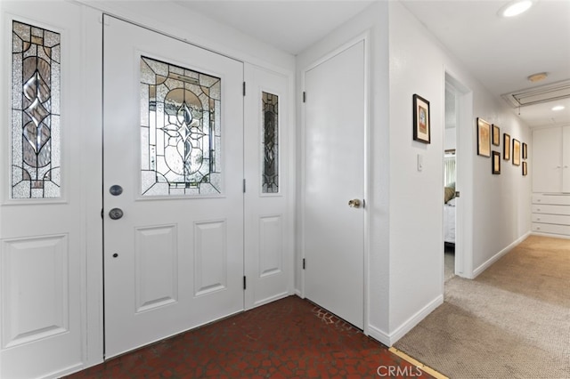 entrance foyer with dark carpet and baseboards