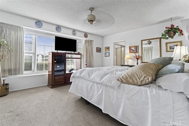 carpeted bedroom featuring a textured ceiling, ceiling fan, and multiple windows