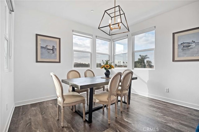 dining space featuring dark wood-type flooring and a notable chandelier