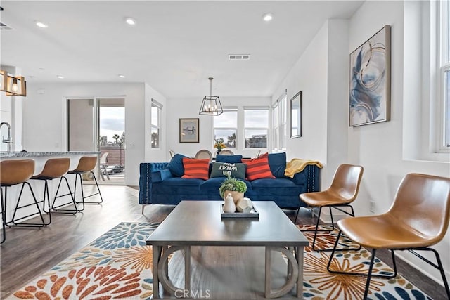 living room featuring an inviting chandelier and wood-type flooring