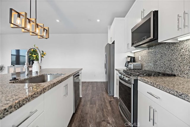 kitchen featuring stainless steel appliances, sink, hanging light fixtures, and white cabinets