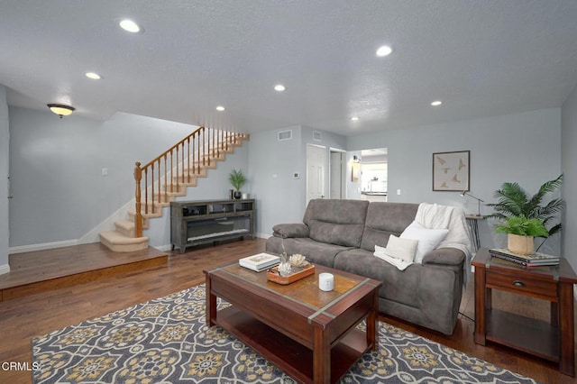 living room with dark wood-type flooring and a textured ceiling