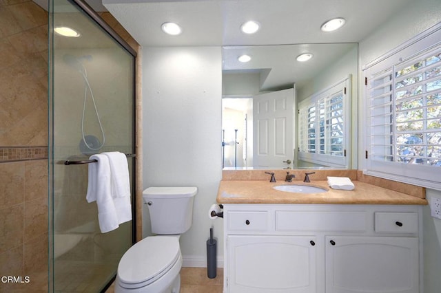 bathroom featuring tile patterned flooring, vanity, an enclosed shower, and toilet