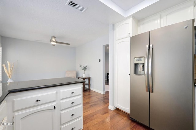 kitchen with dark hardwood / wood-style floors, white cabinets, ceiling fan, and stainless steel fridge with ice dispenser