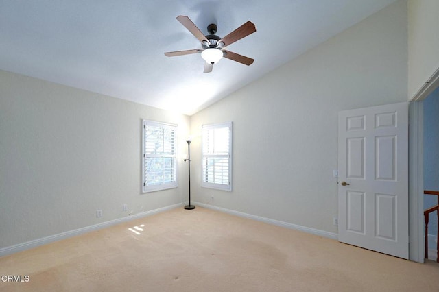 carpeted spare room with vaulted ceiling and ceiling fan