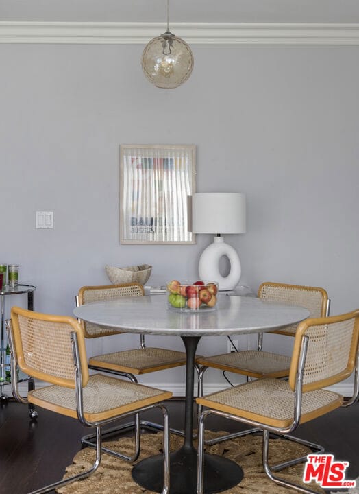 dining area with breakfast area, crown molding, and wood-type flooring